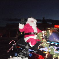 Santa on a snowmobile sleigh.